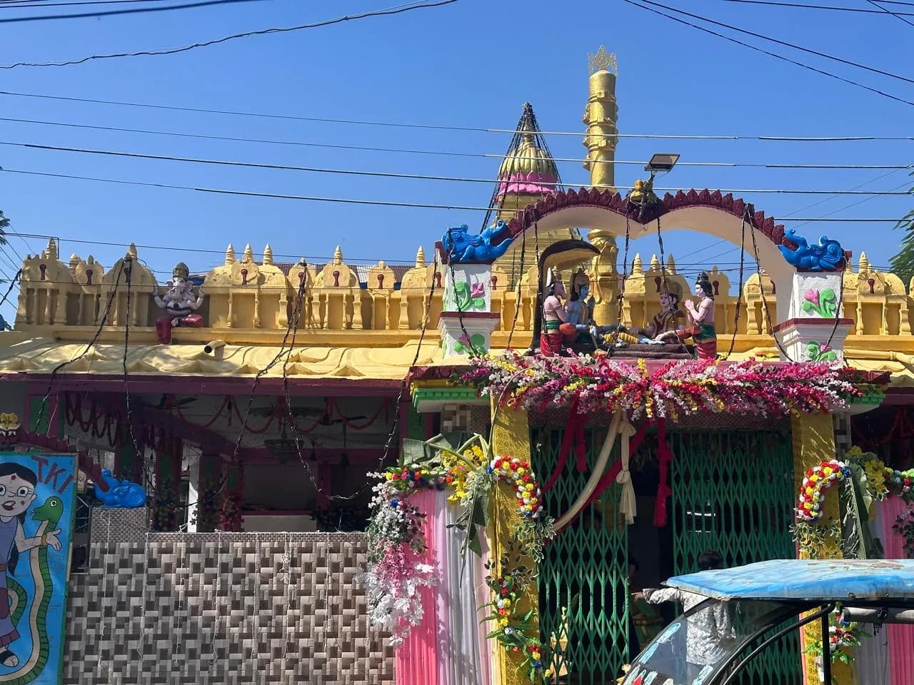 Main entrance of Sri Venkateswara Swamy Temple at Rail Bazaar, Alipurduar, with a decorated archway and golden flagstaff