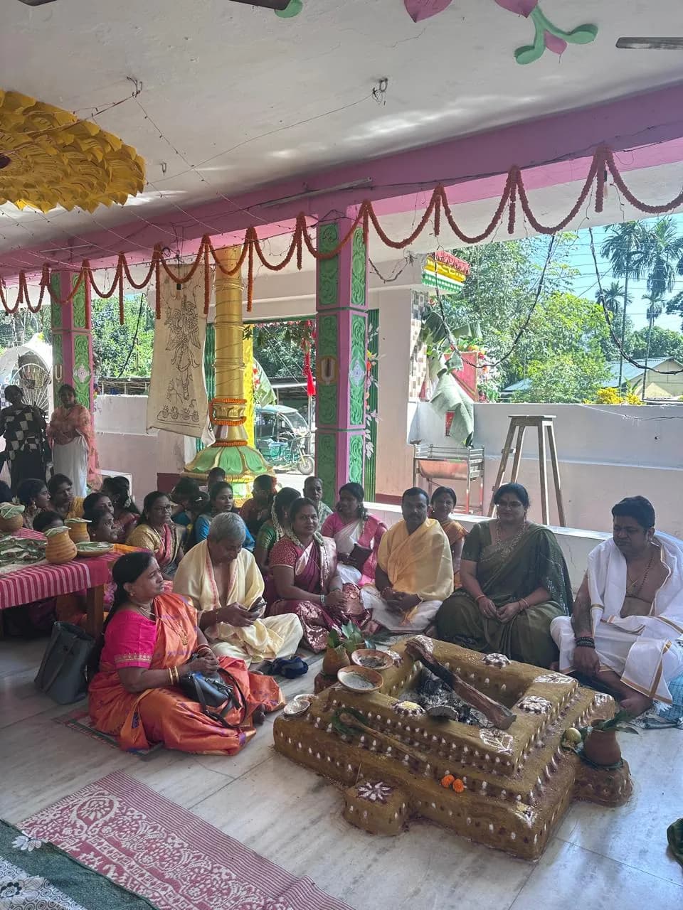 Community seated around a ceremonial fire altar in the pavilion of Sri Venkateswara Swamy Temple