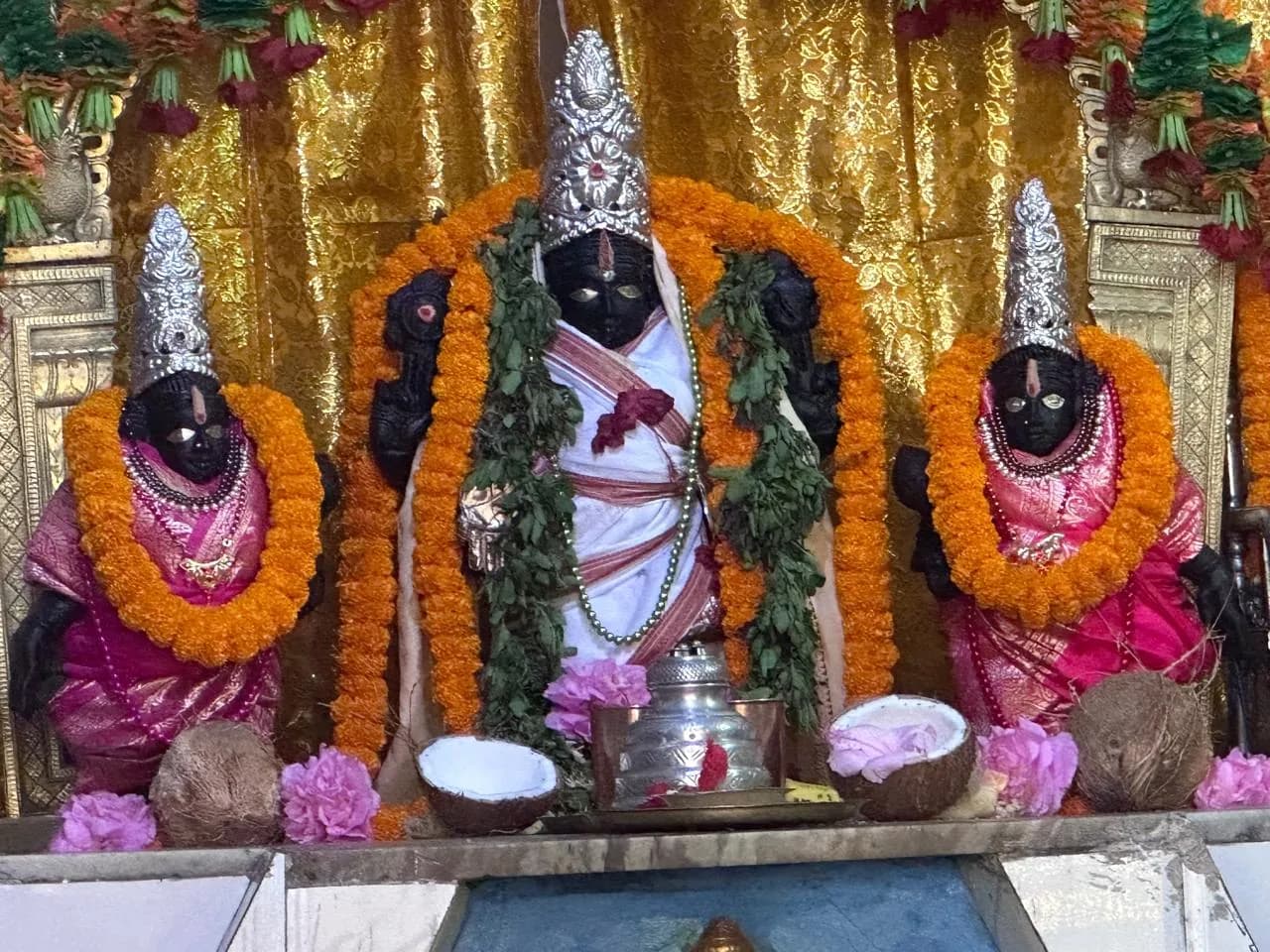 Principal deities at Sri Venkateswara Swamy Temple, adorned with silver crowns and flower garlands